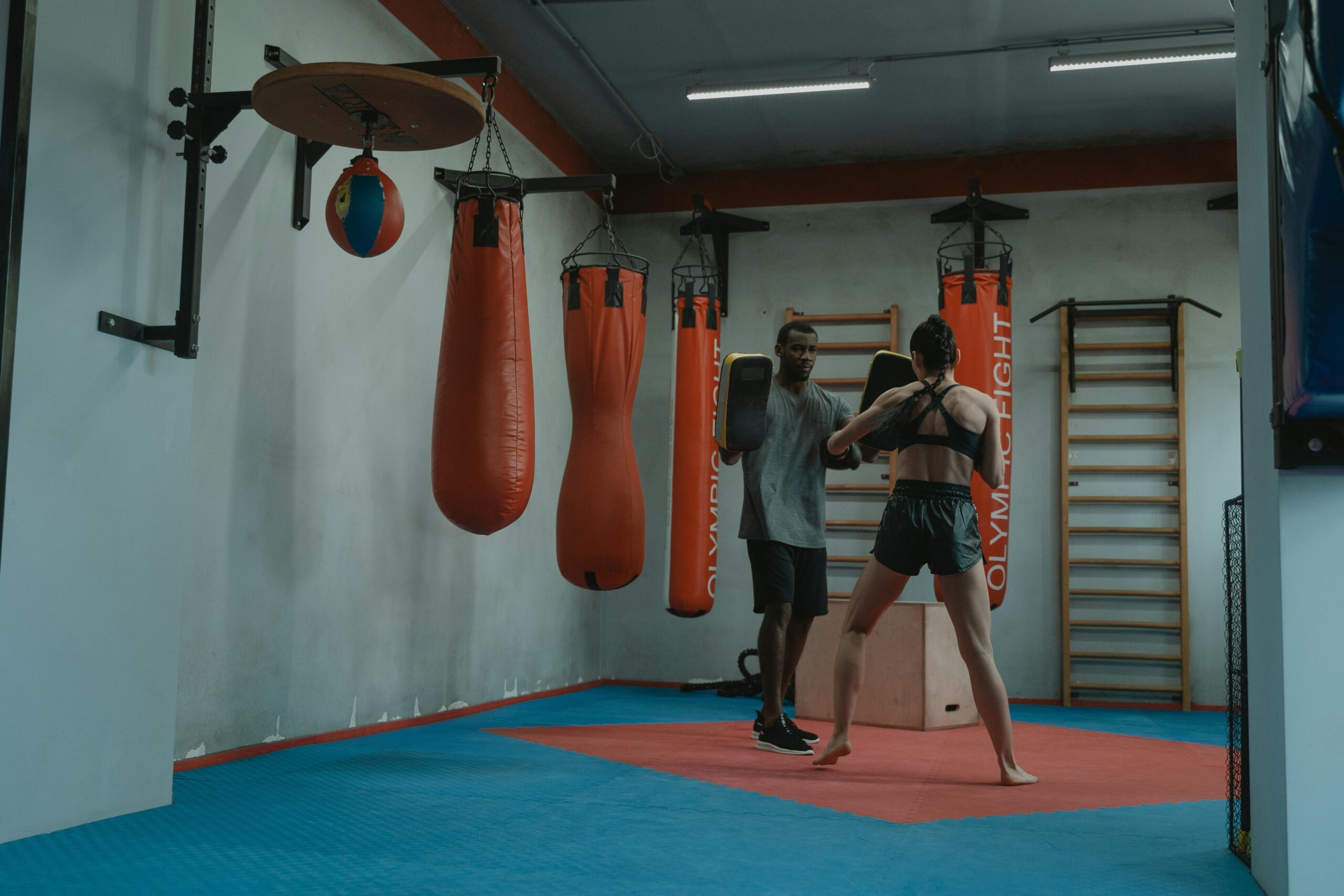 Un professeur de boxe avec son élève dans une salle d'entrainement